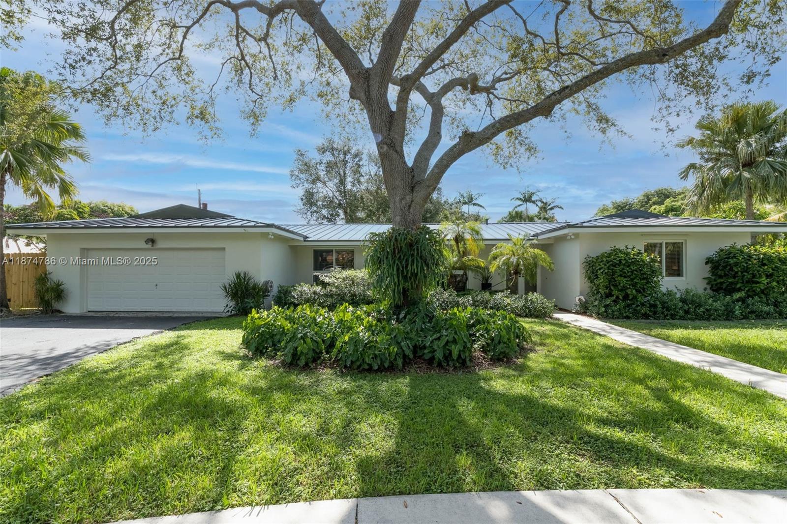 Gorgeous 4 bdrm, 2 bath home on a spectacular oversized lot in Palmetto Bay. Newly painted exterior. New metal roof installed: 2023. Impact windows. Sun-filled formal living & dining rms w/ gorgeous floor to ceiling windows, plantation shutters & neutral tile floors. Open kitchen features oversized island w/ seating, double ovens, gas stove & sliding corner windows w/ adjacent family rm complete w/ cozy bookshelves. Primary suite overlooks the lovely backyard, has walk-in closet & bath w/ glass enclosed shower, jetted tub, double sinks. Lush, private backyard w/ mature trees, fully fenced w/ double gate; plenty of space to park your boat or build a pickle ball court! Plus pool, covered patio. 2 car garage.