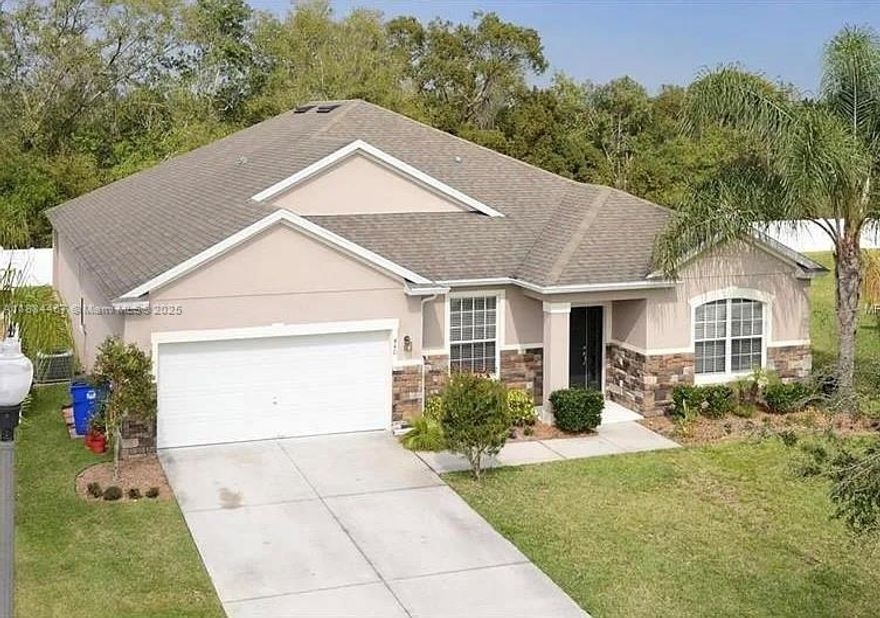 Welcome to this inviting 4-bed, 3-bath residence.  Move-in ready, it features solid block construction, elegant porcelain tile floors, and arched accents. A flexible layout includes formal dining and living rooms plus a spacious family room that flows into a chef’s kitchen with granite countertops, solid wood cabinetry, and nickel finishes. Large sliders open to a covered lanai and fenced backyard ideal for relaxing or entertaining. The primary suite offers patio access, two walk-in closets, and a spa-style bath with dual vanities, a corner tub, and a glass shower. A laundry room with extra storage, a two-car garage and proximity to Lake Tohopekaliga, Lake Nona.
