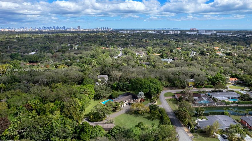 Luxurious country living meets paradise on stunning 1.5+ acre corner lot in South Miami! This mid-century modern jewel offers 4 BD/4BA and 5,500 sf of living space with serene canal views and lush tropical landscaping including mature tropical fruit, oak & banyan trees. The secluded multi-level estate boasts a soaring cathedral ceiling, 42’ heated pool, jacuzzi, multiple indoor/outdoor patio terraces ideal for entertaining, indoor cabana room, 3,000 bottle wine cellar, full house 48 kW Generac generator, gym and nearby tennis courts & private dock. Complete with a detached 1 bd/1ba cottage and 4 zoned stables for your horses. AMAZING OPPORTUNITY within minutes of UM, DOWNTOWN CORAL GABLES, COCONUT GROVE, and Miami’s finest dining, shopping, and entertainment.