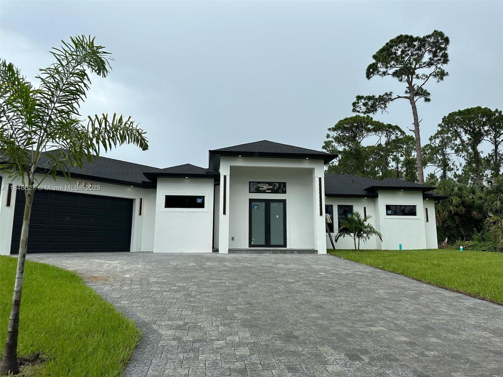 Your Florida Dream Home! This stunning new construction home boasts 3 bedrooms,3 full bathrooms, a 2 car garage, with storm, Impact resistant doors and windows. A perfect place for a growing family. The modern floor plan is truly unique, boasting quartz countertops, and seamless, luxurious tiled flooring throughout, with spectacular LED lighting and plumbing fixtures which all add a touch of elegance. With breathtaking 10ft to 14ft high coffered ceilings and 8ft tall custom doors, this home feels spacious and airy, creating a welcoming, resort styled atmosphere for you and your loved ones. The oversized, half of an acre land space, which offers plenty of space for outdoor activities and plenty of room for pool and RV/Boat. Don't miss out on the opportunity to make this one of a kind house!