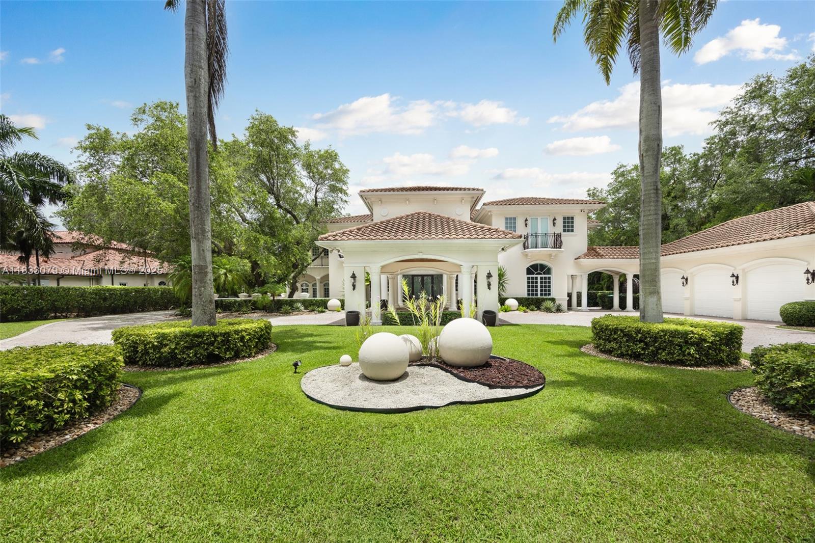 Set on over an acre in lush Pinecrest, this grand two-story estate offers 7 bedrooms and 6.5 bathrooms, including a detached guest house with shared cabana bath. A dramatic foyer introduces formal living and dining rooms divided by a double-facing fireplace. The chef’s kitchen is equipped with Monogram appliances, double ovens, and a central dining space, flowing into the family room and outdoor terraces. With a 13-seat theater, billiard room, and summer kitchen with built-in grill, the home is designed for effortless, year-round entertaining. Additional highlights include a library with custom built-ins, elevator, whole-house generator, and detached A/C 3-car garage. Outside, enjoy a resort-style saltwater pool with grotto and spa, featuring a flexible chlorination system.