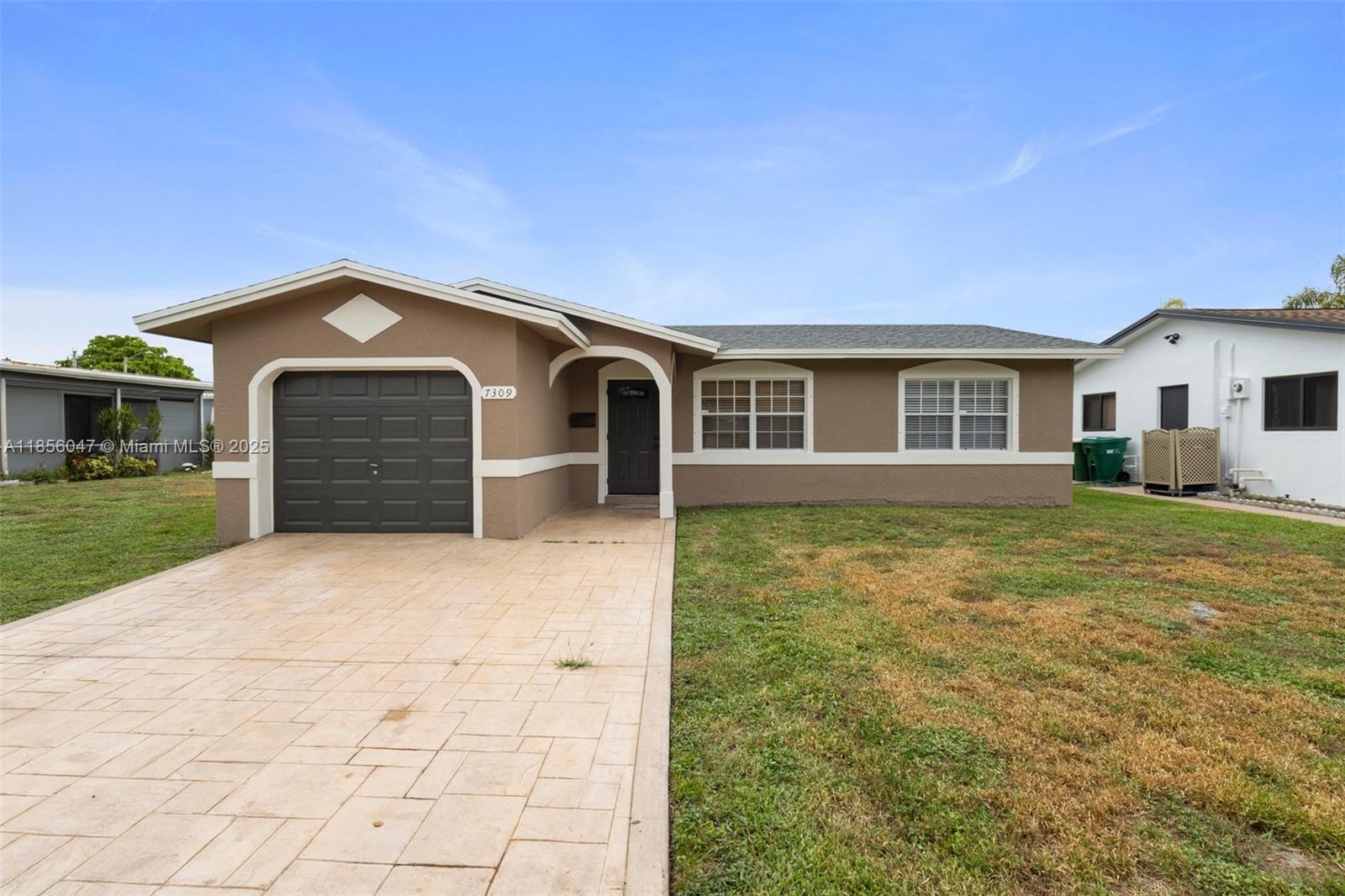 Welcome to a charming 2-bedroom, 2-bathroom home nestled in the vibrant Mainlands of Tamarac. This beautifully maintained residence features a spacious open floor plan with great finishes, including elegant wood-style flooring and a bright, updated kitchen with stainless steel appliances, granite countertops, and ample cabinetry. The inviting living area flows seamlessly into a cozy dining space, perfect for entertaining. Step outside to with a paved driveway and garage, ideal for relaxation or outdoor activities.