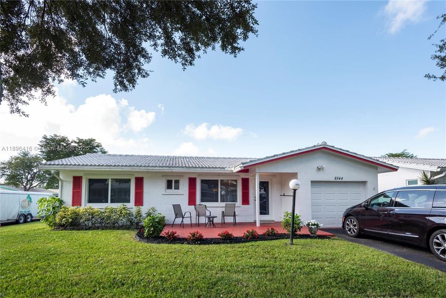Centrally located Lauderdale West **Corner Lot** 2 bed/2 bath w/garage, 55+ Community with new  Impact windows and doors 2024. Newer tiled roof 2019, New AC/Heater 2024 & New hot water tank 2025. Garage door 2023. Roof 9 years old. Eat in kitchen, Living room, dining area and separate family room. Large rooms, primary bed w/large walk in closet-ensuite bath with dual sinks, shower & linen closet Washer, Dryer & fridge in garage stays. Assoc. Fee Includes: Fiber Optic HDTV & Internet, Free community bus at your door, Lawn Service, Exterior painting, Huge Clubhouse, 2 Pools Tennis Courts, Pool Tables, Ping Pong, Card rooms, Professional Shows, Fitness Center & more! This home is a must see! Home can be purchased turn key or emptied out if needed.