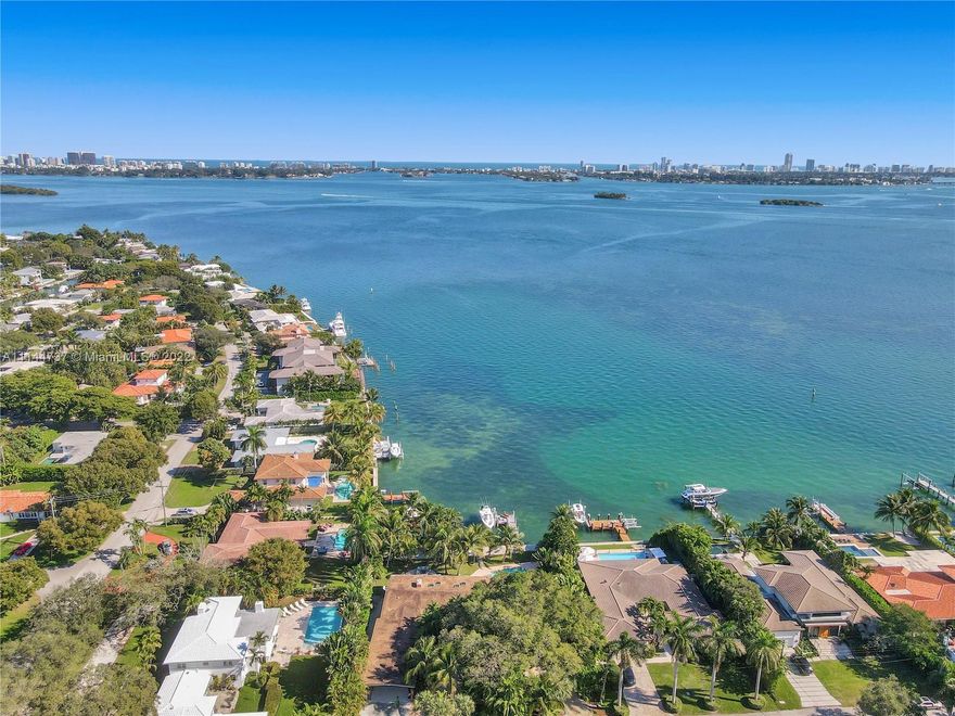 Magnificent, Mid-Century Modern, Open-Bay Waterfront property w/private circular driveway. Features an expansive water view stretching from Surf Side, past Miami Beach and beyond. Mornings deliver the mesmerizing tranquility of a sun-kissed bay. City lights highlight the night. 110 linear ft. frontage; 400 SF dock. Elevated seawall capped with concrete pilings. Palm Trees that outline a massive backyard with pool and your own sandy beach area. 4 bdrm/4bth. Huge Master with sizable, private workout and/or office area. Water views from almost every room. Impact windows and doors. Huge updated kitchen. Wide open living space that is perfect for entertaining. Only a short distance to Design District and Wynwood. Previously the home of Joe Robbie (Miami Dolphins).