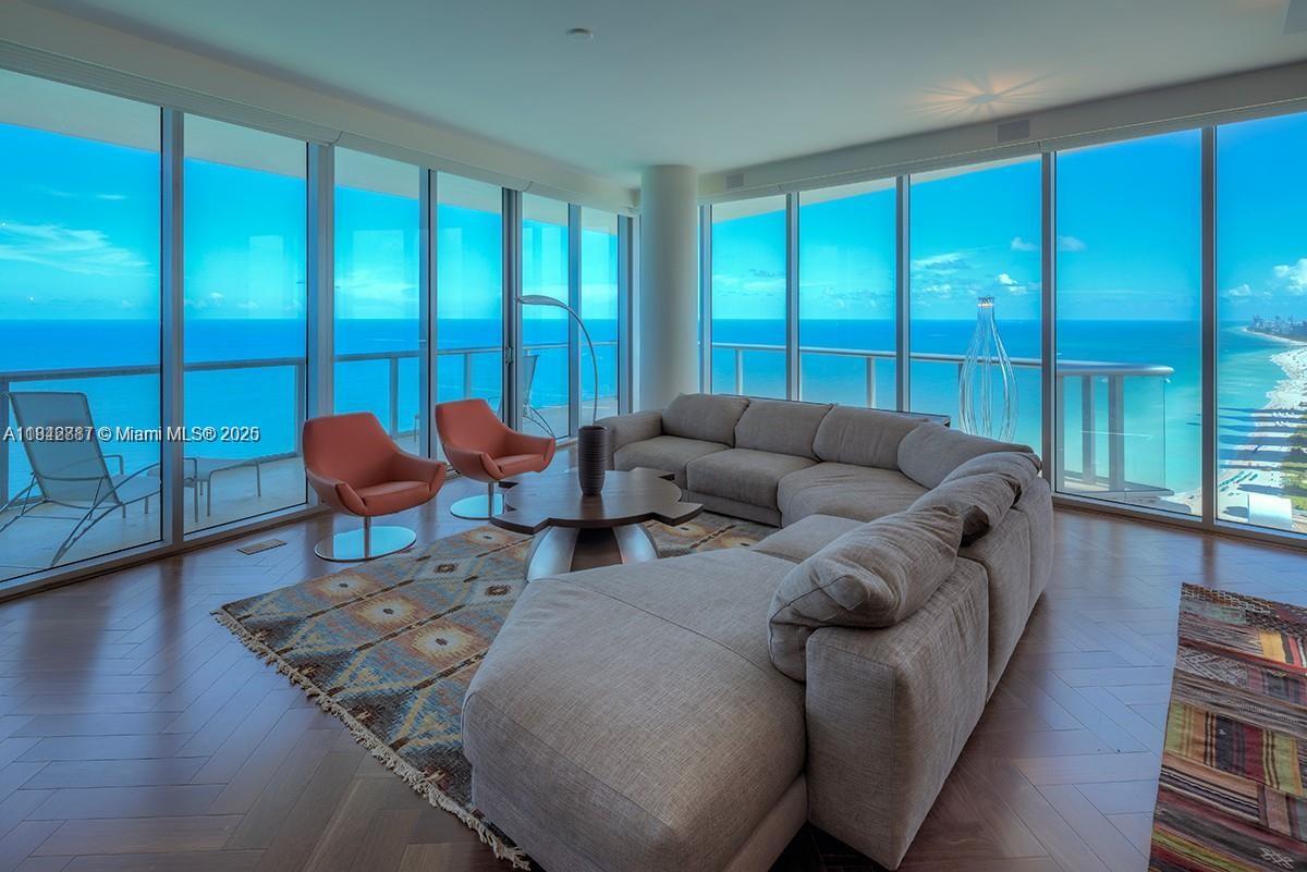 Stunning designer-furnished penthouse on the coveted SE corner of the 43rd floor at Jade Beach! This 4 bed / 5.5 bath residence features 12' ceilings, floor-to-ceiling windows, electric blinds, and two main bathrooms in the primary suite. Private elevator entry, panoramic ocean views, and a BEACH FRONT CABANA included. Enjoy luxury spa amenities, beach service, and iconic beachfront living.