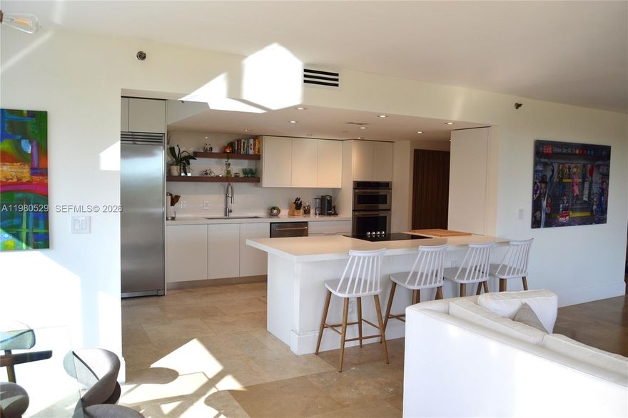 Beautifully fully remodeled luxury corner residence offering 2 bedrooms, 2 full bathrooms plus a guest bathroom, located in an exclusive waterfront building. Modern open layout with over $200,000 in upgrades including marble floors throughout, upgraded electrical wiring and plumbing, fully dimmable recessed lighting, integrated Bose surround sound system, and smart app-controlled A/C with modern diffusers for optimized airflow. Contemporary kitchen features white quartz countertops, stainless steel appliances, and a dedicated wine and beverage refrigerator. Enjoy a wraparound balcony with newly installed flooring enhancing durability and outdoor aesthetics, offering panoramic Biscayne Bay views ideal for relaxing or entertaining. Custom-built spacious closets throughout and flexible space perfect for home office or studio. Full-size washer and dryer conveniently located in a dedicated laundry area with additional storage space. Additional features include covered assigned parking and private storage. Residents enjoy resort-style amenities including bayfront pool, state-of-the-art fitness center, sauna, renovated lobby and social areas, and 24-hour security. Ideally located near beaches, Aventura, Bal Harbour, dining, shopping, and major highways. Turnkey luxury waterfront living.