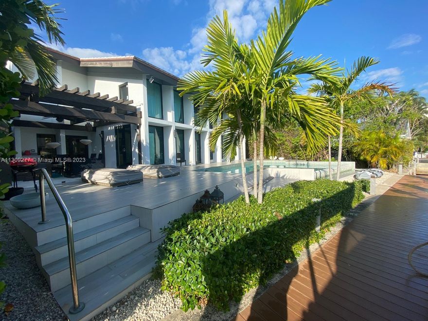 Contemporary waterfront home in Sans Souci Estates designed by renowned architect Barry Sugarman. This unique property is surrounded by lush, tropical landscaping featuring a unique Gumbo Limbo tree, which is the heart of the property. Walnut wood floors, vaulted wood ceilings, Italian-made kitchen with quartz countertops. Improvements include All-new impact windows, new roof, onyx master bath. Truly a boater’s paradise with 88ft of water frontage with easy access to Biscayne Bay & Atlantic Ocean. Spacious deck and high-capacity boat lift. Bedroom 4 converted into Den/studio, can be easily converted as original bedroom.
