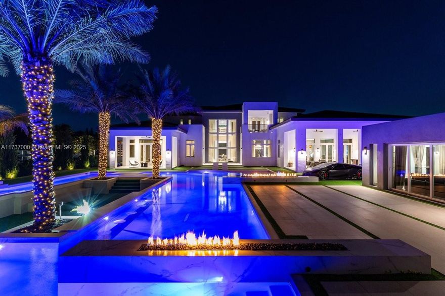 Presenting a monumental custom estate in Southwest Ranches, where no detail is overlooked. This 12,000+ sq.ft. architectural marvel, set on 2.25 acres, features 7 lavish bedrooms, 7 exquisite bathrooms, and 2 opulent half-baths, all masterfully crafted with an unrivaled commitment to perfection. Soaring ceilings and walls of glass bathe each room in natural light, highlighting rare stones and rich woods throughout. Inspired by the world's most elite resorts, this home boasts a sunken entertainment area, a resort-level pool oasis, and a state-of-the-art wellness center with a gym and steam room. Distinctive features include a car showroom theater, a weight-bearing parking area by the pool, and a hidden office overlooking the estate. Schedule a private tour today!