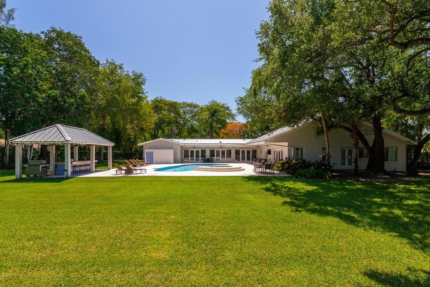 You will be charmed the moment you arrive at this wonderful home which sits on a magnificent and lush 37,156 sq ft property in highly sought-after N Pinecrest.  This 6 bedroom / 4 bath split plan has an updated kitchen that opens to the family room.  The formal living, dining and Florida rooms are all spacious and light-filled. French doors lead to large terrace with pool, a covered gazebo with wet bar & extensive manicured gardens - perfect for entertaining!  The private primary suite includes two office / sitting areas and a substantial master bath & walk-in closet.  Other special features include guest suite w/ separate entrance, gated 2-car garage, cabana bath & gorgeous oaks. Don't miss this unique opportunity that has infinite potential!