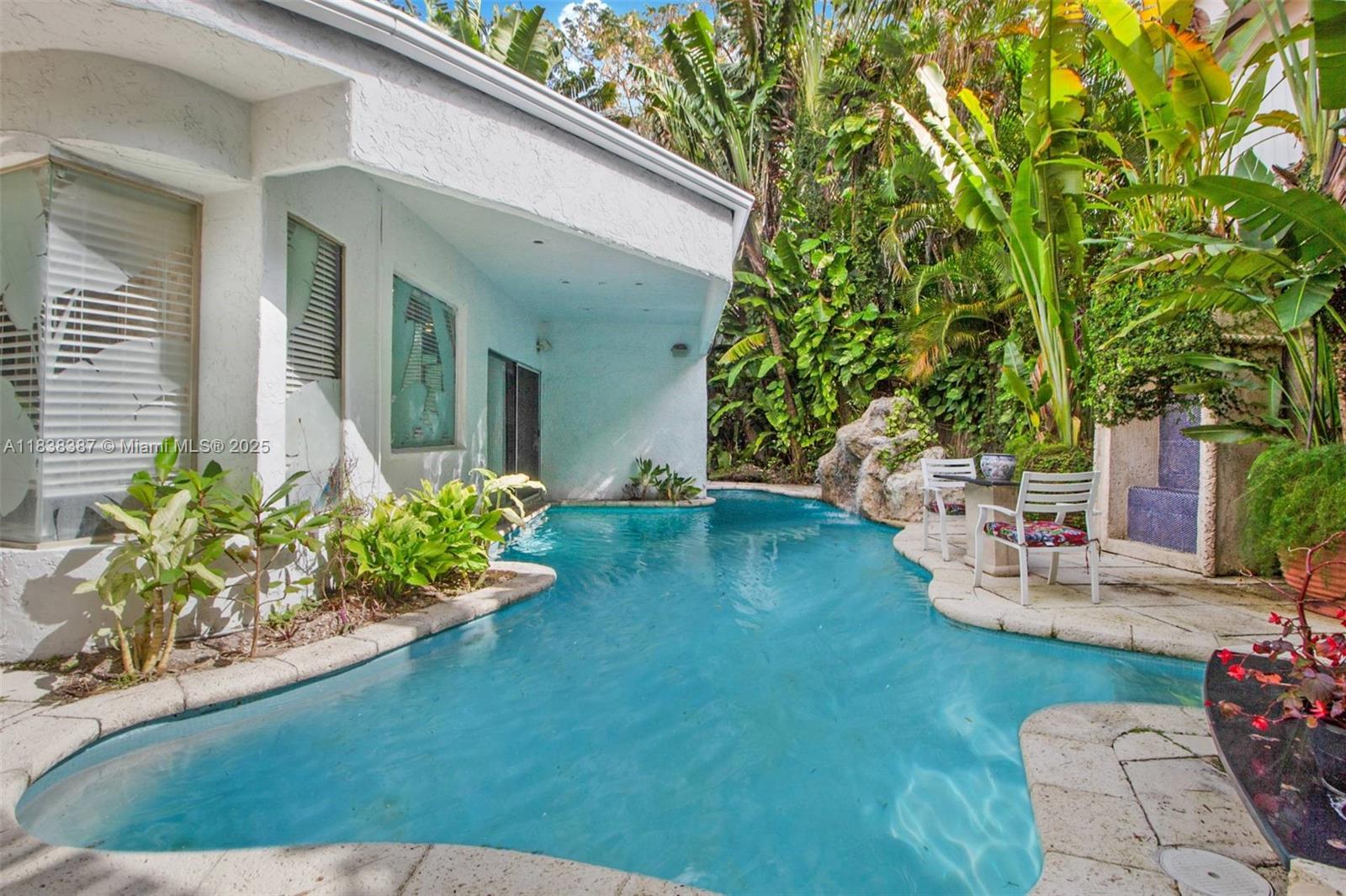 Tropical tranquility meets vintage contemporary charm on coveted Morris Lane in Coconut Grove! This one-of-a-kind property offers the perfect blend of architectural character and opportunity. Reimagine this vintage modern gem or build anew—either way, it’s a wise investment in one of Miami’s most sought-after neighborhoods. The main home features 2 bedrooms and 2 baths, while a separate 1-bedroom/1-bath guest suite provides the ideal setup for working from home or hosting visitors in style. A waterfall pool flows around the primary suite, framed by lush, mature greenery for total privacy and tucked away just moments from Biscayne Bay, marinas, parks and the reimagined CocoWalk. A rare chance to own a truly special home with timeless design and boundless potential in the heart of the Grove.