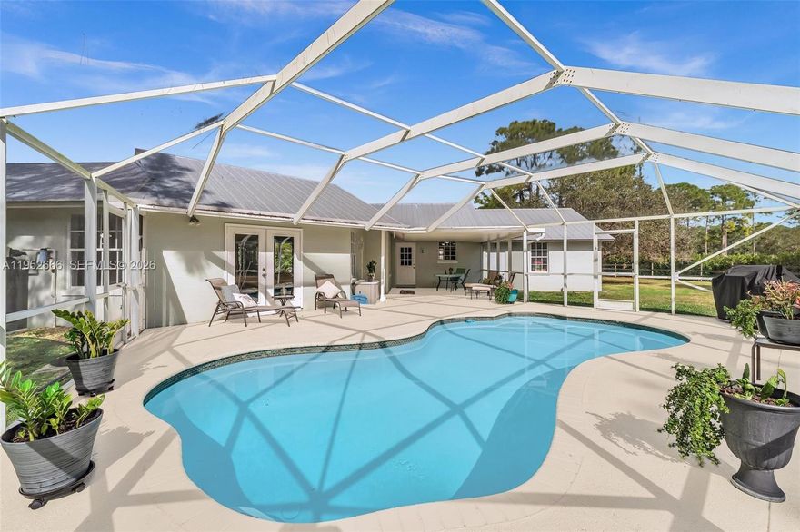 Set within the gated equestrian community of Stuart West, this FULLY FURNISHED Palm City estate sits on a private 2.12 acre corner lot offering space, serenity, and flexibility to grow. The home has been extensively updated with a metal roof in 2018, newer HVAC system in 2023, upgraded water system in 2023, resurfaced pool with new pump in 2022, and hot water heater in 2024, delivering long term value and peace of mind. Inside, the primary suite is a true sanctuary featuring a spa inspired bath and generous walk in closet. Enjoy wide open surroundings, room for outdoor living or equestrian use, and the quiet lifestyle Stuart West is known for, with optional access to The Cape Club and convenient proximity to everyday amenities. SCHEDULE TODAY!