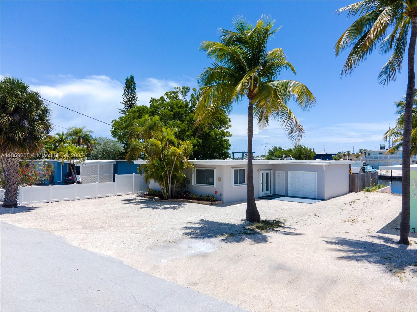 Upper Keys canal front home located at mile marker 90 in Plantation Key Colony. This fully furnished 3 bed, 3 bath concrete block home is situated on a deep water canal, providing quick access to Florida Bay or the ocean. Inside, the home features an open floor plan for entertaining, tile floors throughout, a well-appointed kitchen with plenty of storage, stainless steel appliances, and a separate wine fridge. The exterior features a shady lanai overlooking the canal, low-maintenance landscaping, a 15,000lb boat lift, a jet ski davit, and a storage shed. The neighborhood features a bayfront homeowners' park where you can launch your boat or relax on the lounge chairs and watch a perfect sunset! Perfect full-time residence, or 2nd home with the ability to generate vacation rental income.