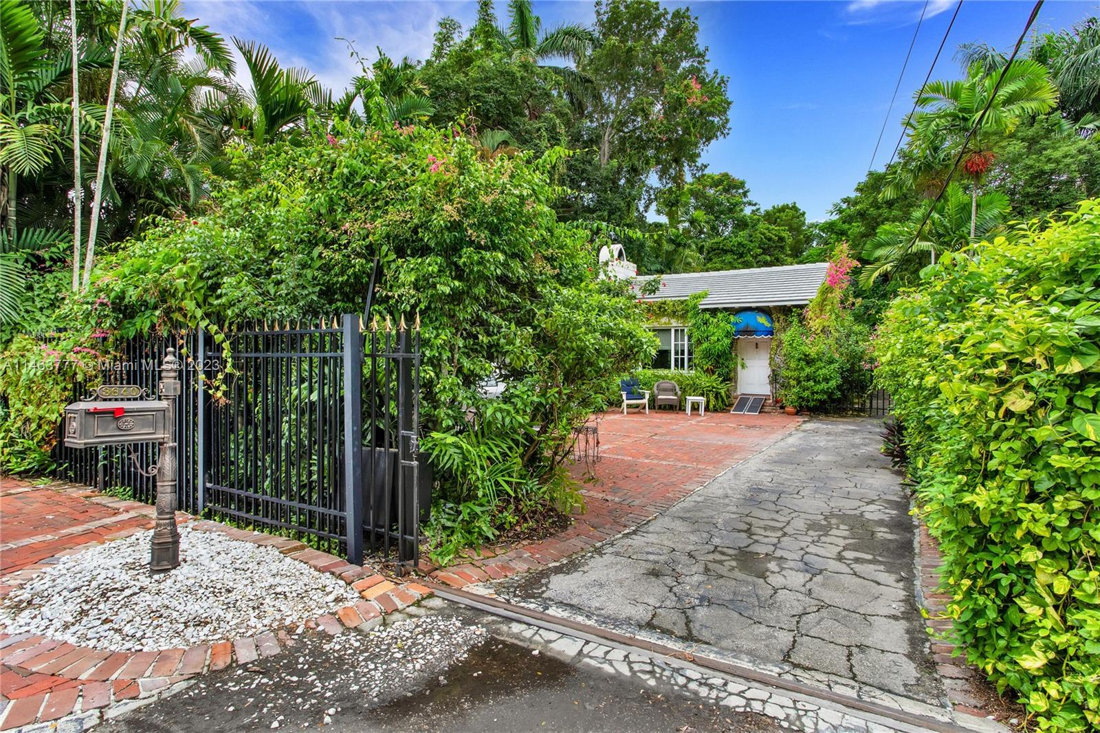 Charming gated home on a tree-lined street in lush South Coconut Grove. Built in 1934 with classic architectural details: vaulted, wood beamed ceilings, original wood & marble flooring, fireplace, French doors & more. Large formal living & dining spaces + 3BR/3BA and light-filled sunroom/office. New tile roof. Expansive 9100 SF lot offers gated parking, mature tropical landscaping, automated sprinkler & lighting systems, a redwood greenhouse, is totally fenced and has a detached 2 car garage. Room to add a pool. 15,000 KW emergency generator. Ready to update to your specifications. Walk or bike to the Grove villages boutiques, cafes and bayfront parks & marinas. Minutes to downtown, MIA, Coral Gables, Key Biscayne & the Beaches.