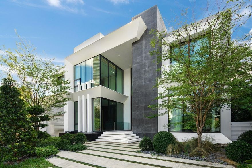 This contemporary waterfront residence, a collaboration between architect Danny Sorogon and interior designer Steven G, showcases bespoke architectural details that enhance its comfort and opulence. Crafted with precision, the home boasts a glass-box elevator, a custom floating staircase, sculptural walls cleverly concealing hidden doorways, and exquisite stonework finishes, creating a truly unique design. Luxurious amenities, including a Veneta Cucina chef’s kitchen with Wolf and Subzero appliances, 27-foot ceilings and expansive glass walls offering stunning Intracoastal Waterway views. A new dock for your showpiece yacht, and indulge in the resort-style pool, spa, summer kitchen, and an oversized rooftop terrace and games deck. Live grandly in this masterfully designed family residence.