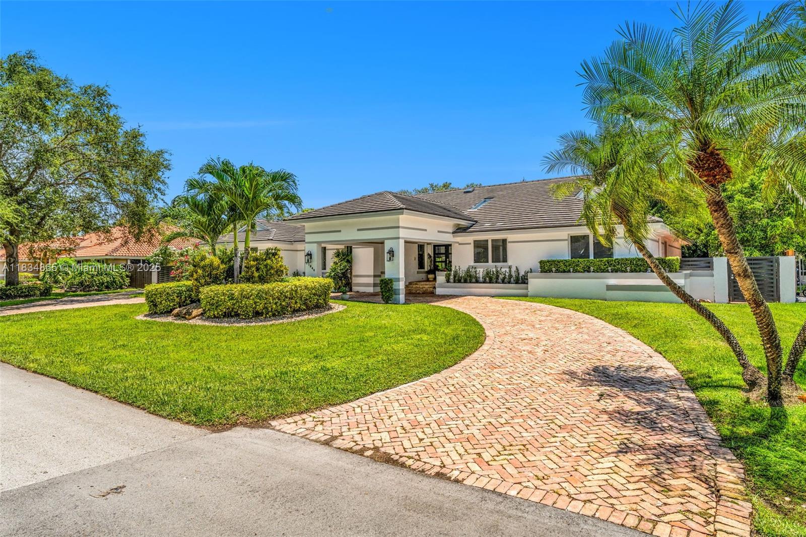 This stunning Palmetto Bay home has it all, space, style, and charm! Fully updated with soaring ceilings, impact windows, lush landscaping, fresh exterior paint, and a whole-house generator for uninterrupted power. The chef’s kitchen offers abundant storage and opens to a large family room. A separate living room with fireplace creates the perfect setting for entertaining or quiet nights in. Extra room is ideal for a home office. The oversized primary suite features two walk-in closets and a spa-like bath. One guest room has an ensuite. Outside, enjoy a resort-style yard with covered terrace, full outdoor kitchen, and a sparkling pool with a custom dolphin fountain art piece. Circular driveway with portico, side driveway, and 2-car garage complete this exceptional home!