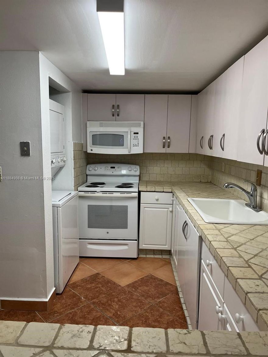 ** SECTION 8 WELCOME ** Spacious 2-bedroom, 2-bathroom condo on the first floor of Building 4 with a private fenced terrace. Bright interior with fully tiled floors throughout, a functional kitchen featuring tile countertops, ample cabinetry, passthrough to the living area, and in-unit stacked washer/dryer. Both bathrooms are nicely updated, and bedrooms offer generous closet space. Located in the desirable Samari Lake community, offering gated entry, security, two swimming pools, clubhouse, and one assigned parking. Close to Westland Mall, Amelia Earhart Park, Bucky Dent Park, major grocery stores, dining, and public transportation, with easy access to Palmetto Expressway and nearby schools. No pets allowed.