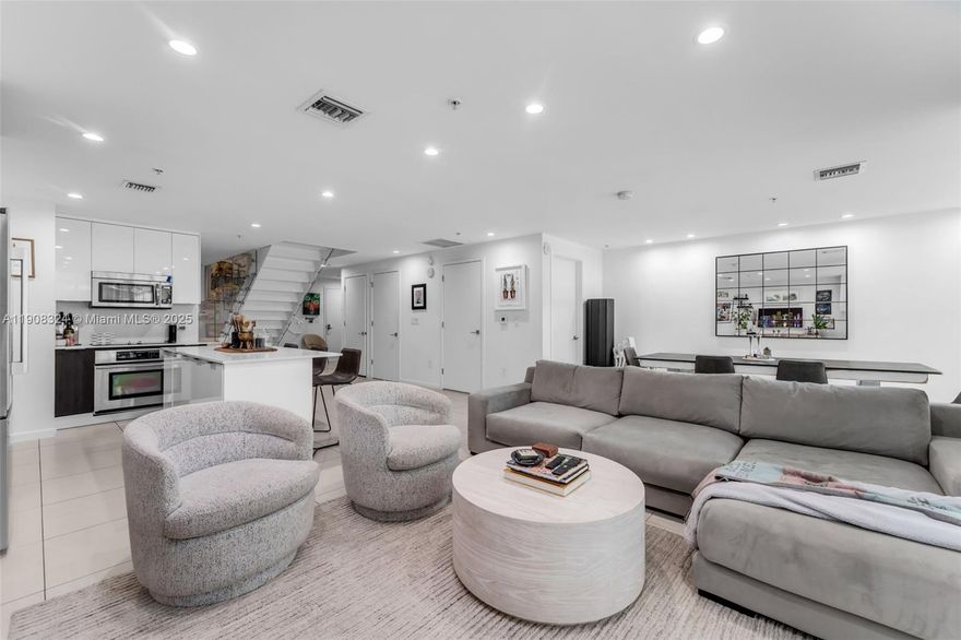 Exceptional 2-story residence offers 3/3 at Four Midtown, featuring 1,945 sqft of living space and a 65 sqft balcony. Totally remodeled, with a custom glass staircase, wood flooring, and an open-concept layout. The remodeled kitchen includes premium appliances and a spacious den/work area—perfect for a live-and-work lifestyle. Upstairs, soaring ceilings and floor-to-ceiling windows create a light-filled atmosphere. Both bedrooms are generously sized, offering the feel of two primary suites. On the lower level, a flexible third bedroom with an en suite bath currently opens to the living area, providing additional space. Enjoy resort-style amenities: fitness center, sparkling pool, business lounge, and 24-hour concierge. Welcome to Midtown—one of Miami’s most vibrant neighborhoods!