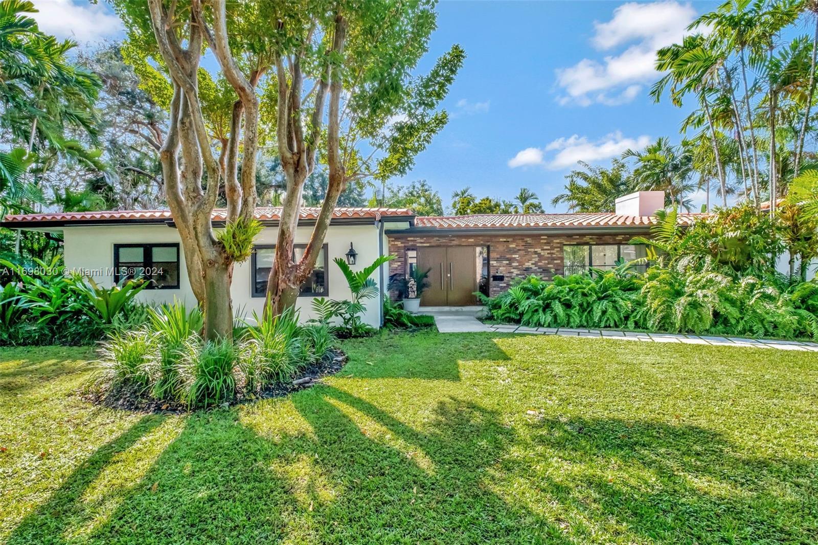 Completely renovated 3-bedroom, 3-bathroom home on a beautiful tree-lined block in Coral Gables, situated on a spacious 10,500 sqft double lot. This stunning property features a brand-new roof, soffit, fascia and gutters (2024), impact windows and doors (2024). All-new porcelain tile flooring throughout. The open-concept design includes a large integrated family room, dining area, and living room, perfect for modern living and entertaining. The chef's kitchen boasts a custom-made cabinets, cooking island, quartz countertops, and all-new smart stainless steel appliances. Two bedrooms are en-suite, including a master suite with a backyard view and a large walk-in closet. A new Wifi irrigation system enhances the lush outdoor space. Move-in ready with modern upgrades and charming curb appeal!