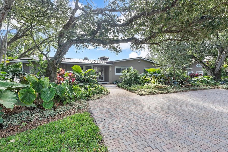 Canal front 3 bedroom 4 1/2 baths home on 18,480 SF gorgeous lot on quiet tree lined street. Sun filled large rooms include high soaring ceilings, impact glass and large closets. Eat-in kitchen with cooking island, wet bar and desk area. Office, library room in main house easily convert to fourth bedroom. The master suite includes a fireplace and 2 walk in closets, plus more closets and storage. Guest house has new full kitchen, 2 story ceiling, bath and loft. Side entry 2-car garage, brand new roof and spectacular landscaping!