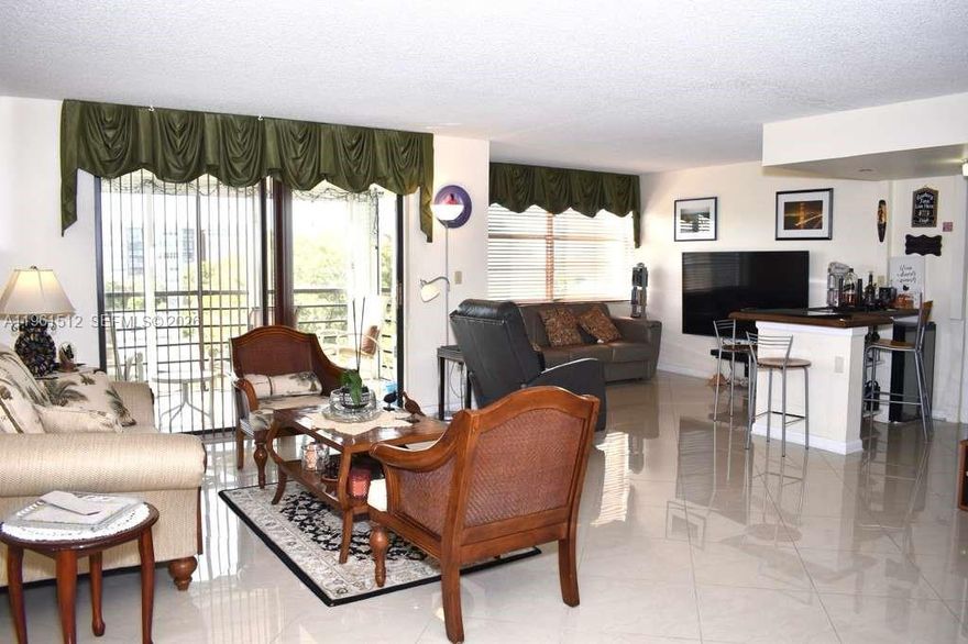 Beautifully remodeled and kept BANYAN unit, with modern decor. This is the largest model in the building with the 3rd bedroom opened up into a den area with a bar! Kitchen and bathrooms renovated, master bathroom has a powder room and walk in shower with modern tiles plus there are three closets, two of which are walk in closets. Stainless steel appliances. Large porcelain tiles set on the diagonal, with wooden floors in bedrooms. Lots of closet space throughout the unit. Just move right into this very desirable Park Place community which has expansive landscaped grounds overlooking golf course and tennis courts. Newly landscaped park. Amenities include, library, tennis courts, clubhouse with activities, internet & cable, water, gym, sauna and 4 heated pools, jogging/walking path. Laundry room on the same floor. This is a 55+ community, 2nd resident allowed to be 19+, association requests 20% down CONV, rentals  allowed but currently at capacity. Furniture negotiable.