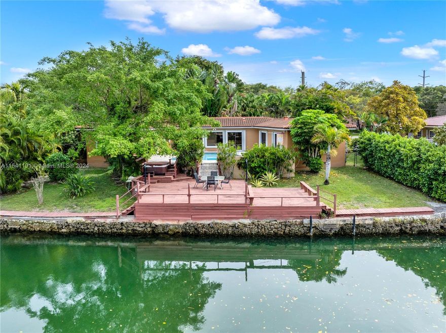 Nestled in the heart of Coral Gables, the City Beautiful, this 4/4 home is a true gem, offering waterfront living with a beautiful pool. Perfectly positioned near US1, it provides convenient access to the University of Miami, top-rated schools, shopping, downtown, the beaches, and Miami Int. Airport. This house has a great split plan layout with the primary bedroom on one side and three additional bedrooms on the other. The kitchen is a nice size, and the house has an open floorplan framing the pool, conducive for entertaining. The seawall was recently reenforced and there is a large private deck on the waterway; creating a peaceful and serene place to watch the sunset and the perfect place to dock your boat.  Bigger than tax record: as per appraiser 2,446 Living Area square footage.
