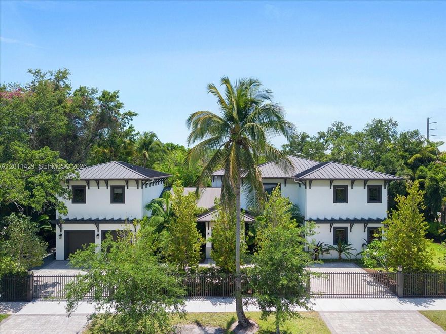 Located in the highly desirable Baptist district, this exceptional tropical modern estate sits on a 15,052 SF lot and offers 7 BD, 6 BA, sophisticated design, and resort-style living. A grand dual-entry driveway and wood-paneled entry porch lead into dramatic interiors featuring soaring vaulted ceilings, recessed lighting, and expansive open-concept living spaces. The great room seamlessly integrates the living, dining, wet bar, breakfast area, and designer kitchen, with sliding glass doors opening fully to the outdoor terrace for effortless indoor-outdoor living. The chef’s kitchen is appointed with custom cabinetry, quartz countertops and backsplash, a large center island, secondary prep sink, and premium Wolf, Sub-Zero, Miele, and Asko appliances. Outdoors, enjoy a striking geometric heated pool with waterfall feature and spa finished in teal mosaic tile, surrounded by a travertine deck, lush tropical landscaping, artificial turf, and a fully equipped summer kitchen with Wolf grill and Big Green Egg. The upstairs primary suite is a luxurious retreat with private terrace, wet bar, custom walk-in closets, and spa-inspired bath with dual vanities, Roman tub, frameless double shower, and dual smart water closets. Additional highlights include a private guest/in-law apartment, elevator, dedicated office, upstairs laundry, Savant smart home automation, ADT security, four A/C units, and a 2-car garage. A rare luxury offering in one of Kendall’s most sought-after locations.