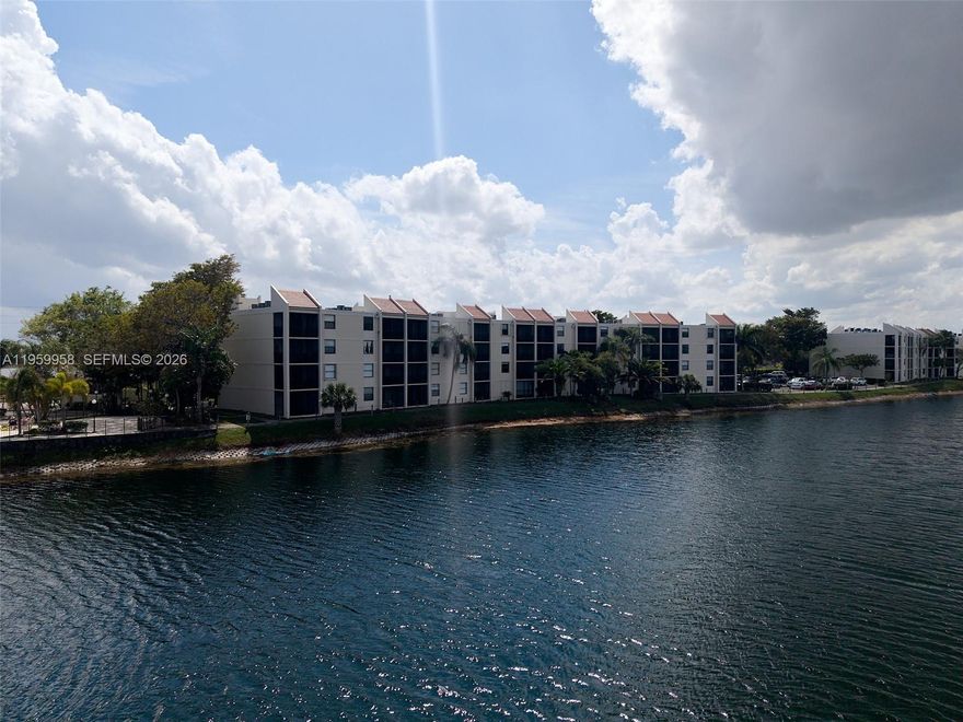 Beautiful 2-bedroom, 2-bath lakefront residence offering serene water views and a spacious private balcony—perfect for enjoying your morning coffee or unwinding at sunset. The thoughtfully designed layout provides comfortable living spaces, abundant natural light, and a peaceful waterfront ambiance throughout. Located in an affordable, well-maintained community, residents enjoy an array of resort-style amenities, including three sparkling swimming pools, a fully equipped fitness center, clubhouse, tennis and basketball courts, and scenic picnic areas ideal for relaxing or entertaining. On-site management and 24-hour guard-gated security provide added convenience and peace of mind. Cable and internet are included in the maintenance fee, and small pets are welcome. Enjoy the unique perk of on-site restaurant service available on weekends and special occasions. Additionally, this building shares the same power grid as the nearby fire station, allowing for quicker power restoration during storms or outages. The unit features partial accordion hurricane shutters on the front-facing windows (kitchen and front bedroom). The primary bedroom window and both balcony sliding glass doors (living room and bedroom) are not equipped with shutters. Whether you’re looking for a full-time residence or seasonal retreat, this lakefront gem offers comfort, security, and exceptional value.