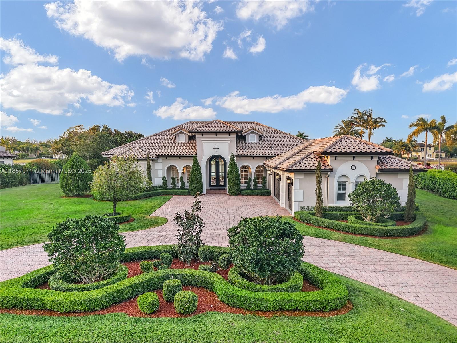 Stunning renovated 5-bedroom, 5-bathroom + office lakefront estate on 1 acre in gated Woodbridge Ranches, Davie. Features include a 15-foot-high iron door, new impact windows and doors (2023), a heated pool and infinity spa (2020), a gourmet kitchen with an island & wet bar, and marble floors.
Upgrades: 2 newer A/C units(2020), new lighting & exterior paint (2023), renovated baths & bedroom floors, central vacuum, and 3-car garage. Circle driveway. Luxury, comfort, and lake views in one exclusive home.