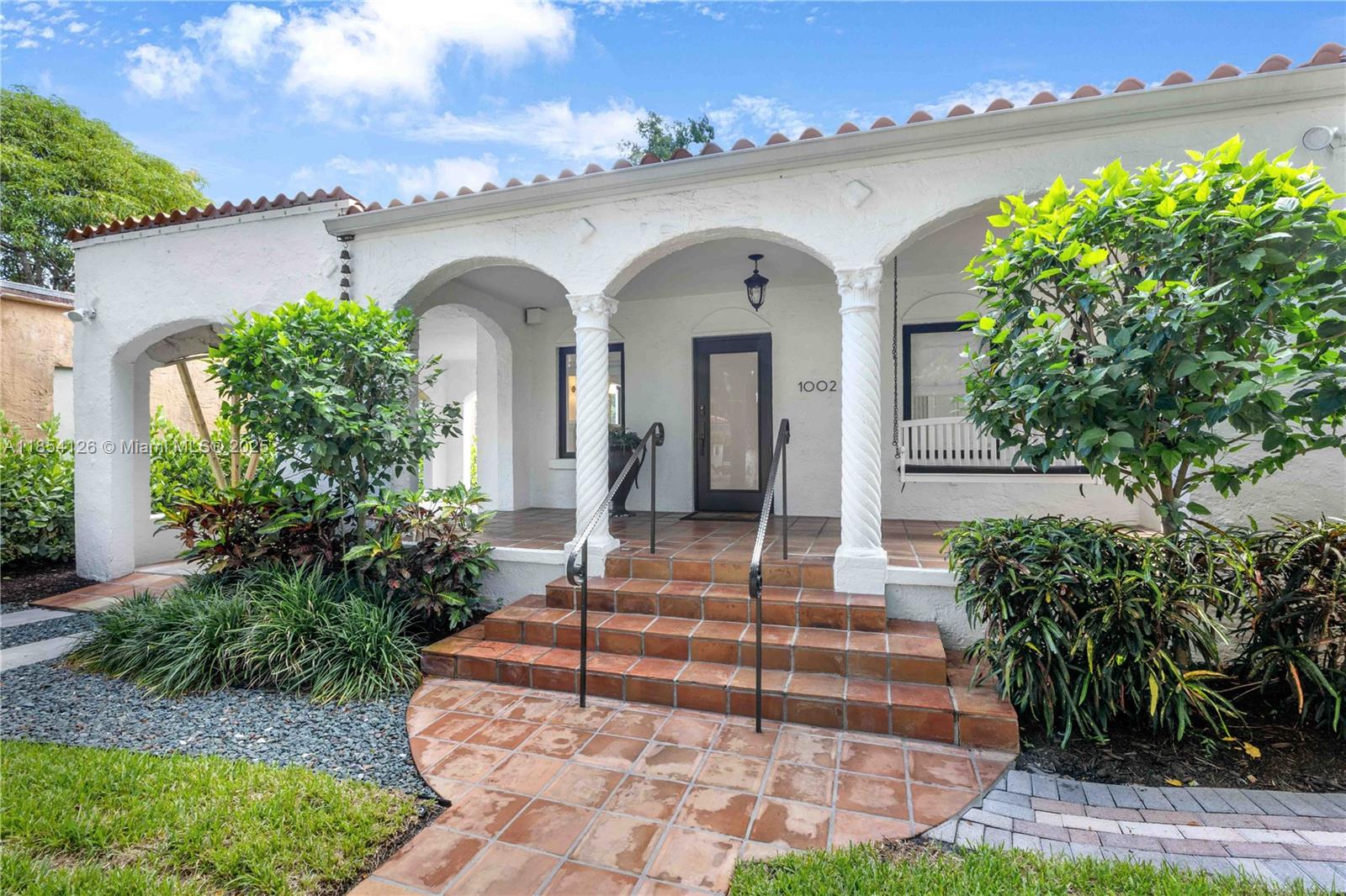 A picture-perfect gem in North Gables! This turnkey home showcases sophisticated living with luxury finishes throughout. From the welcoming covered porch, gleaming hardwood floors flow seamlessly through sun-drenched open living spaces centered around a stunning fireplace. The beautifully renovated chef's kitchen features high-end appliances and abundant storage, while updated bathrooms feature premium contemporary design. No detail was spared including generous custom closets and new impact windows. Step through french doors to enjoy the spacious bricked patio — perfect for entertaining. This exceptional property combines elegance with comfort in a highly desirable neighborhood minutes from top schools, parks and downtown Coral Gables.