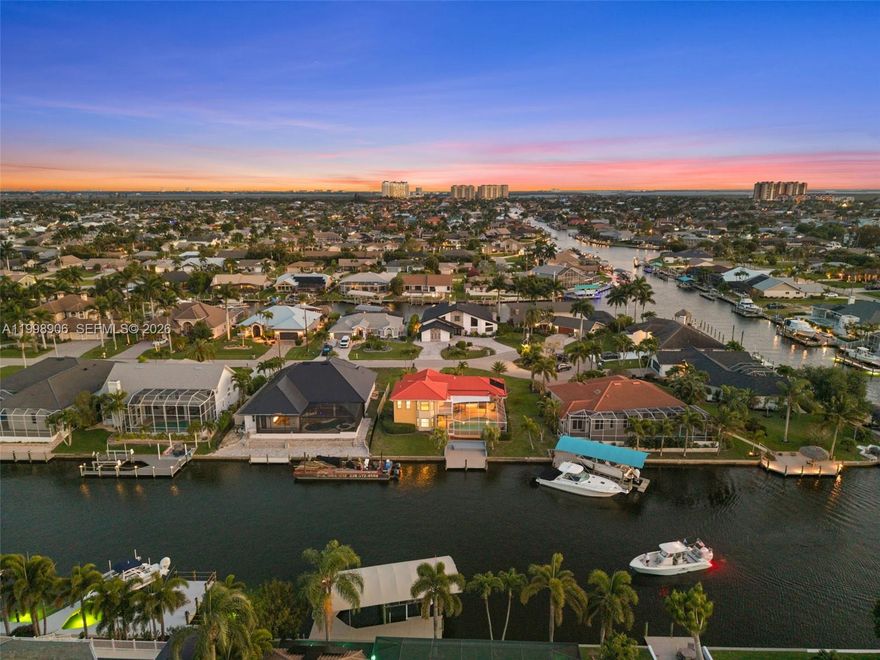 JUST A SHORT BOAT RIDE AND NO BRIDGES TO OPEN WATER! DIRECT GULF ACCESS, 2-STORY HOME WITH 2 PRIMARY SUITES, POOL, AND 125-FOOT WIDE CANAL VIEWS! Welcome to 1223 SW 51st St in the sought-after Unit 64 area of SW Cape Coral. This 4 bedroom + den, 3 bath waterfront home offers 2,856 sq ft, direct deep-water sailboat access, and a cul-de-sac location on the Finn Canal, a 125-foot-wide canal off the Gloriana Canal. With no bridges and no locks, you have quick access to the Caloosahatchee, Gulf, beaches, Cape Harbour, Tarpon Point, and more. The flexible layout includes two living areas, a bright open kitchen, indoor and outdoor dining, and a den perfect for an office or flex room. A standout feature is the two primary suites, one downstairs with pool access and one upstairs with a sitting area and private balcony, ideal for guests or multigenerational living. The guest bath also serves as a pool bath with a soaking tub. Recent improvements include lanai pavers, pool tile and surfacing, balcony work, and an expansion-ready dock, plus quartz countertops, soft-close cabinetry, updated appliances, remodeled baths, interior and exterior paint, LVP upstairs, epoxy garage floor, 2 complete A/C systems, updated electrical panel, water heater, metal roof, impact-resistant windows in key areas, and custom shutters. The solar-heated pool has an approximately 6-foot deep end. If boating, poolside living, and a prime SW Cape Coral location are on your list, you need to see this home!