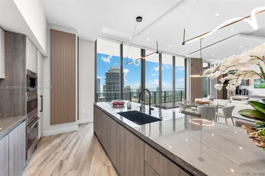 Experience the ultimate in luxury with this fully custom penthouse, featuring a one-of-a-kind open floor plan designed for entertaining. Offered fully furnished and equipped. Living spaces are illuminated by custom lighting from 11-foot recessed ceilings, complemented by imported custom finishes throughout. With over 500 square feet of outdoor terrace, enjoy breathtaking water and skyline views. Indulge in resort-style living with access to SLS Lux's five-star amenities. The penthouse includes two large, side-by-side parking spaces for convenience. Attention: This penthouse features an open floor plan reconfigured to include one dedicated primary bedroom and a large den accommodating two additional Murphy beds, making it ideal for a couple or bachelor/bachelorette.