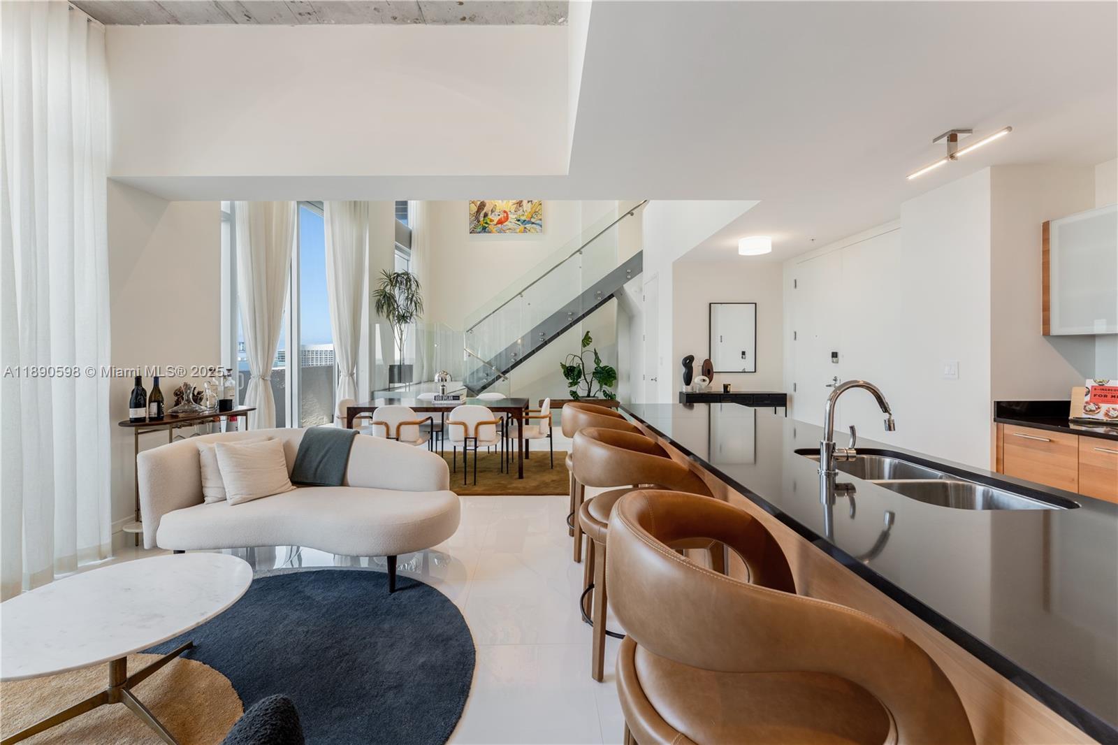 Best-priced two-story penthouse in Midtown Miami!
This rare 2,400+ SF residence features soaring 20-ft ceilings, floor-to-ceiling glass, and sweeping bay & city views. Designed for art collectors and creatives, it offers 3 bedrooms + den, 3 full baths, and a sleek modern kitchen flowing into expansive living areas. Flooded with natural light, this home blends design, comfort & sophistication. Enjoy resort-style amenities including a fitness center with yoga studio, business lounge, pool, 24-hour security & 2 covered parking spaces. Prime Midtown location surrounded by new developments, parks, dining & retail—buy into one of Miami’s most exciting billion-dollar neighborhood transformations underway!