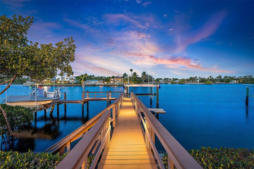 Enjoy breathtaking Easterly views of the wide water, overlooking the Loxahatchee River, from this exceptional home located on a private island in the prestigious Islands of Jupiter. Thoughtfully designed for comfort and functionality, this residence features a ground-floor primary suite, an elevator, and a large upstairs loft that can be used as a gym or an entertaining area. Recent upgrades include a brand-new 2024 roof, fresh landscaping with new trees, and newly installed synthetic turf for easy maintenance. Boating enthusiasts will love the private dock with a lift, offering quick access to the Jupiter Inlet and nearby sandbars. The spacious three-car garage provides ample storage, while the lush outdoor setting enhances the natural beauty of this property.
