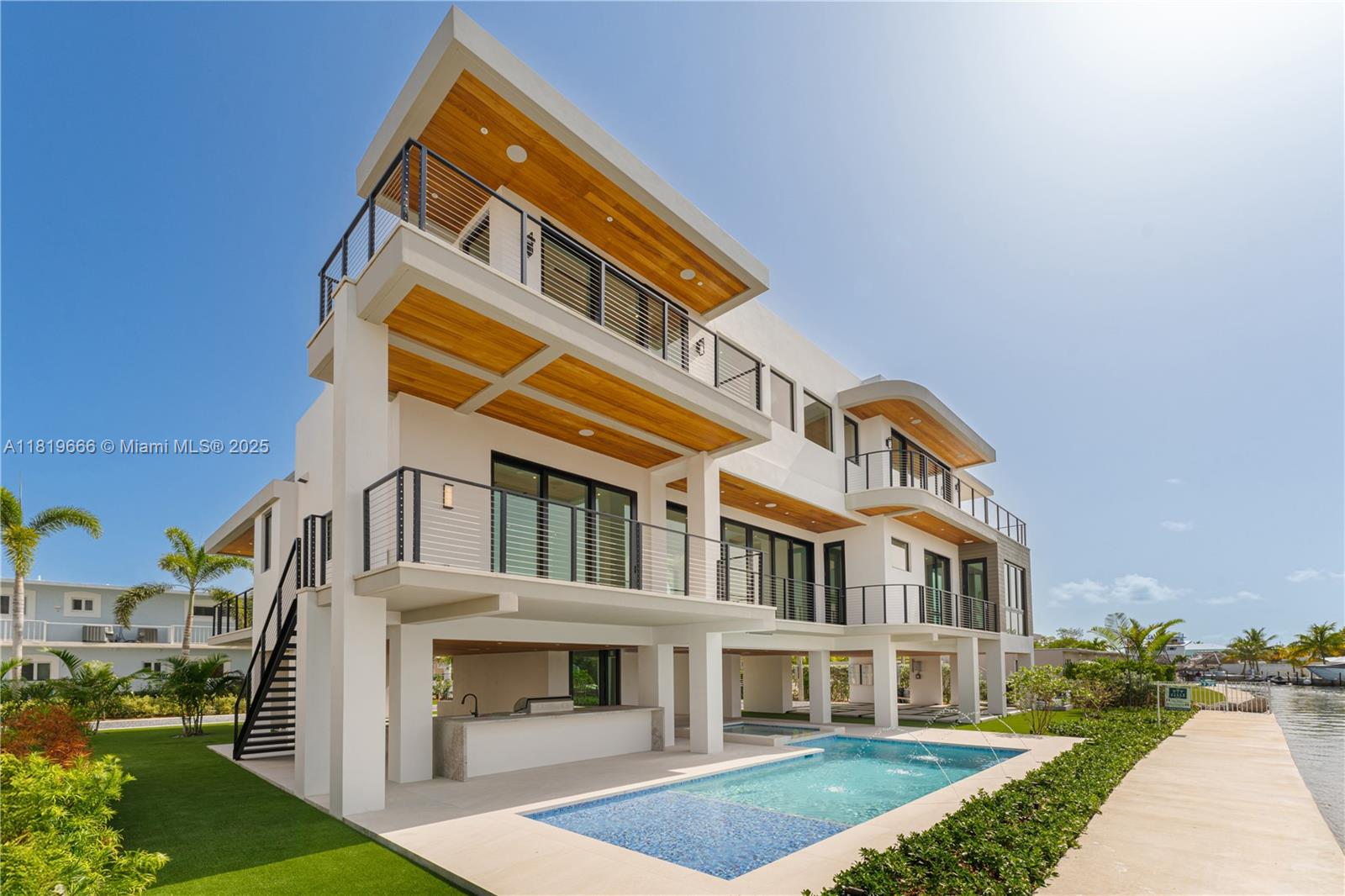 Extraordinary 6,043 Sq.Ft. waterfront home with the finest quality finishes, set in a private enclave at Buttonwood Circle. This entertainer's dream home offers spacious living and dining areas with a gourmet kitchen. Highlights include a gorgeous main suite with a spacious balcony and a luxurious bath equipped with a spa tub, separate shower, and large walk-in closet. Enjoy the desirable Florida Keys indoor-outdoor lifestyle with seamless access to landscaped grounds, which will include a sparkling pool, full summer kitchen, and private 45-foot dock. Featuring four additional bedrooms with ensuite bathrooms and a rooftop deck ideal for entertaining and enjoying spectacular views, this is a true retreat and a must-see!