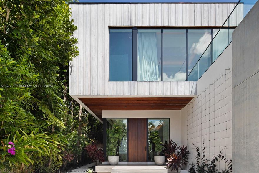 Step Inside With Me! 609 East Dilido seamlessly fuses nature and design for tropical living on the Venetian Islands. Built by Bart Reines and impeccably styled by its designer-owner, it juxtaposes teak, concrete, wood, glass and greenery. Interior highlights include retractable glass windows, custom millwork, specialty lighting & a white marble kitchen with Gaggenau appliances. A floating staircase leads to chic office loft + 4 suites. With over 1,200SF, the Primary is a true escape featuring ambient lighting, open concept marble bath, enviable dressing closet, and wraparound terrace with open bay views. This smart home fully controls lighting, air, music and more. The pool, rooftop deck, summer kitchen, solar panels, landscape, amazing dockage & 2 car garage complete the outdoor package.