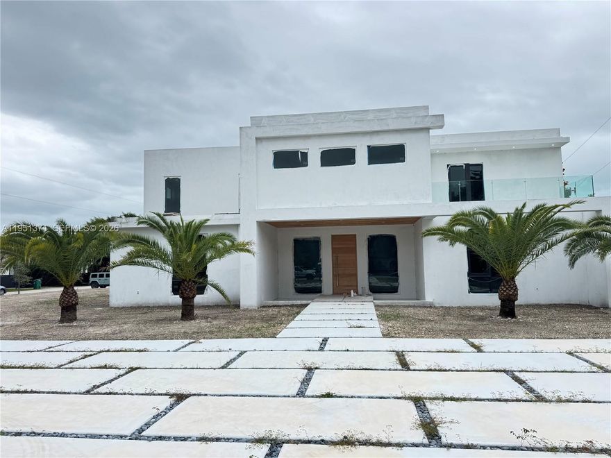 A rare opportunity to own a newly completed modern estate in the heart of prestigious Pinecrest. Set on a quiet, tree-lined street, this architectural masterpiece blends bold contemporary design with refined luxury and exceptional craftsmanship. Walking above the reflection pond entrance feature, taking in the striking façade and through the dramatic solid-wood pivot door into the grand double-height entry, the home makes an immediate impression. Walls of glass flood the interiors with natural light and create a seamless connection between expansive living spaces and the outdoors—ideal for both everyday living and elegant entertaining. The residence offers eight spacious bedroom suites, each with a private spa-inspired bath. The primary suite is a true retreat with a lavish bathroom, oversized custom closets, huge balcony and serene views. The chef’s kitchen is a showpiece, featuring brand new appliances, custom cabinetry, an oversized island, and walk-in pantry, opening to sophisticated family and dining areas. Designed for indoor-outdoor living, the resort-style backyard features a stunning resort style pool with swim-up bar and spa, a concrete gazebo with summer kitchen, and lush landscaping—your own private oasis. Additional highlights include a dramatic skeleton staircase, media room, huge laundry, service quarters and a multi-car garage. Minutes from top-rated schools and parks, this is not just a home—it is a statement.