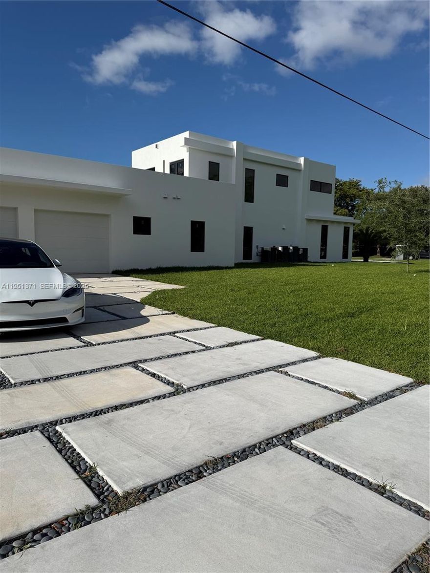 A rare opportunity to own a newly completed modern estate in the heart of prestigious Pinecrest. Set on a quiet, tree-lined street, this architectural masterpiece blends bold contemporary design with refined luxury and exceptional craftsmanship. Walking above the reflection pond entrance feature, taking in the striking façade and through the dramatic solid-wood pivot door into the grand double-height entry, the home makes an immediate impression. Walls of glass flood the interiors with natural light and create a seamless connection between expansive living spaces and the outdoors—ideal for both everyday living and elegant entertaining. The residence offers eight spacious bedroom suites, each with a private spa-inspired bath. The primary suite is a true retreat with a lavish bathroom, oversized custom closets, huge balcony and serene views. The chef’s kitchen is a showpiece, featuring brand new appliances, custom cabinetry, an oversized island, and walk-in pantry, opening to sophisticated family and dining areas. Designed for indoor-outdoor living, the resort-style backyard features a stunning resort style pool with swim-up bar and spa, a concrete gazebo with summer kitchen, and lush landscaping—your own private oasis. Additional highlights include a dramatic skeleton staircase, media room, huge laundry, service quarters and a multi-car garage. Minutes from top-rated schools and parks, this is not just a home—it is a statement.