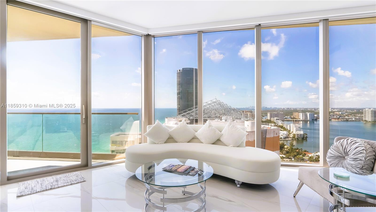 This rare 2-bedroom corner luxury condo offers the most desirable layout, featuring panoramic floor to 10 ft-ceiling glass walls with breathtaking southeast-facing views of the ocean, bay, and city from every room. With 1,661 sq ft, this modern architectural gem includes a den and 2.5 marble-finished bathrooms. Elegant white Italian flooring throughout including 2 balconies. Enjoy cooking with a view in this gourmet kitchen with top-of-the-line appliances plus wine cooler & high-performance washer/dryer. Enjoy world-class amenities including a private restaurant, multiple bars & cigar lounge. Beach-front yoga studio, spa, salon & gym. Resort-style pool with direct beach access and full service. 24-hour valet and concierge services. Centrally located between Miami and Fort Lauderdale.