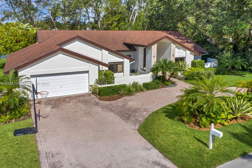 Nestled in central Miami, this exquisite 5-bed, 4-bath residence sits by a tranquil lake, with easy access to highways, shopping, and dining. Welcomed by a graceful foyer, guests are led to an expansive living room and rear terrace, blending indoor-outdoor living. The left wing features a well-appointed kitchen, spacious living/dining area, formal dining space, and a bedroom with an on-suite bathroom. The right wing boasts 4 bedrooms and 3 bathrooms, ensuring ample accommodation. Natural light bathes the home, creating warmth through the hurricane impact windows. A 2-car garage and circular driveway offer convenience and ample parking.