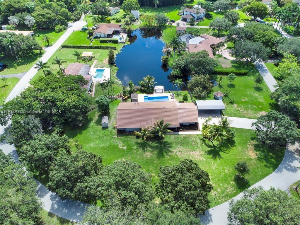Don't Miss Out!!! This property IS FOR SHORT TERM RENTAL, Situated on a sprawling 1.53-acre corner lot with lake views in Davie, this exquisite single-family home combines elegance with modern comfort. It features 4 beds, 3 baths, a 3-car garage, and a durable metal roof. Renovated with sleek porcelain tiles, a stunning quartzite island, impact-resistant windows, two tankless water heater, two air conditioning units, zebra blinds, and custom-built closets. Your private backyard oasis includes a sparkling pool, an above-ground jacuzzi, and a collection of tropical fruit trees, including mango, banana, tamarind, and starfruit. Located in a sought-after neighborhood known for its luxury and privacy, this home is truly a rare find.