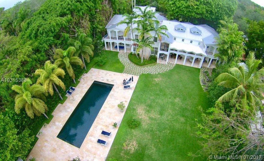 Hamptons in the Grove - Custom-built with discerning detail, the estate offers a prime location on a builder’s acre of exquisitely landscaped and lush gardens, including a 100-year old Banyan tree that greets you upon arrival.  This walled estate with 8-foot walls surrounding the property offers exceptional privacy and security.  Features include a grand main house with 35-foot ceilings and lots of natural light, a 2-bedroom guest quarters above the 5-car garage with a full kitchen, a luxurious guest house at far end of the pool, media room constructed with floating floors and soundproofed walls, gourmet kitchen, 5,000-bottle wine cellar, heated pool with silver copper filtration system, diesel full-house generator, Crestron smart-home system and much more.