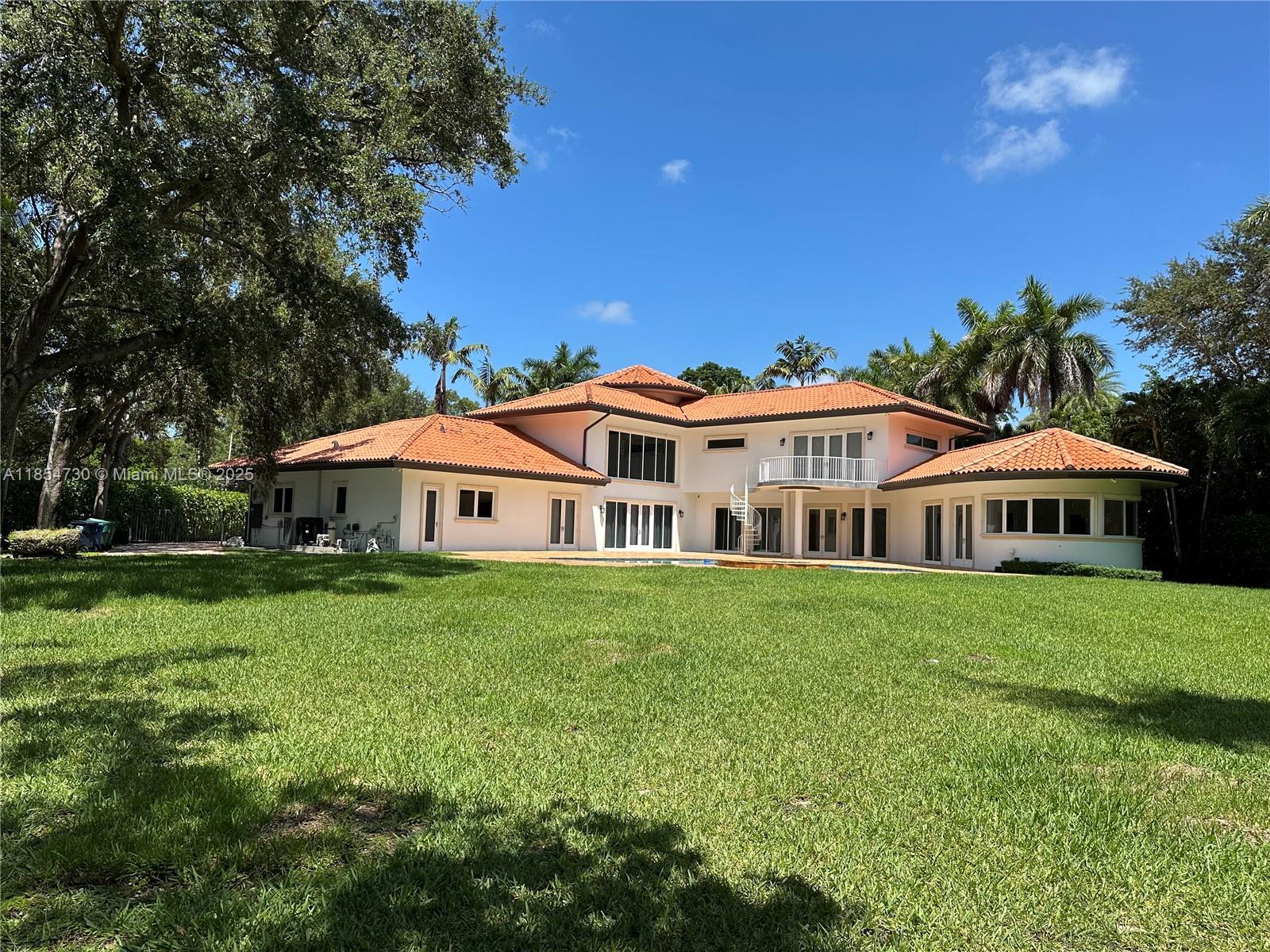 Gorgeous, gated estate spans 5,849 sq ft on 40,519 sq ft of land, offering 6 spacious bedrooms and 4.5 marble bathrooms. The interior showcases elegant marble and porcelain flooring, a fully renovated design with high-end finishes, and a gourmet kitchen featuring GE Monogram appliances and new wall oven/microwave. The private second-floor primary suite includes a marble shower, jacuzzi tub, custom walk-in closet with built-in dresser, and a private balcony with direct pool access. Each bedroom has an en suite walk-in closet, en suite bathroom, complemented by a private office and a solarium room. Outdoors, enjoy a heated pool, jacuzzi spa, 145 feet of canal frontage with koi fish, and impact windows for added security and efficiency. Your dream home starts here!