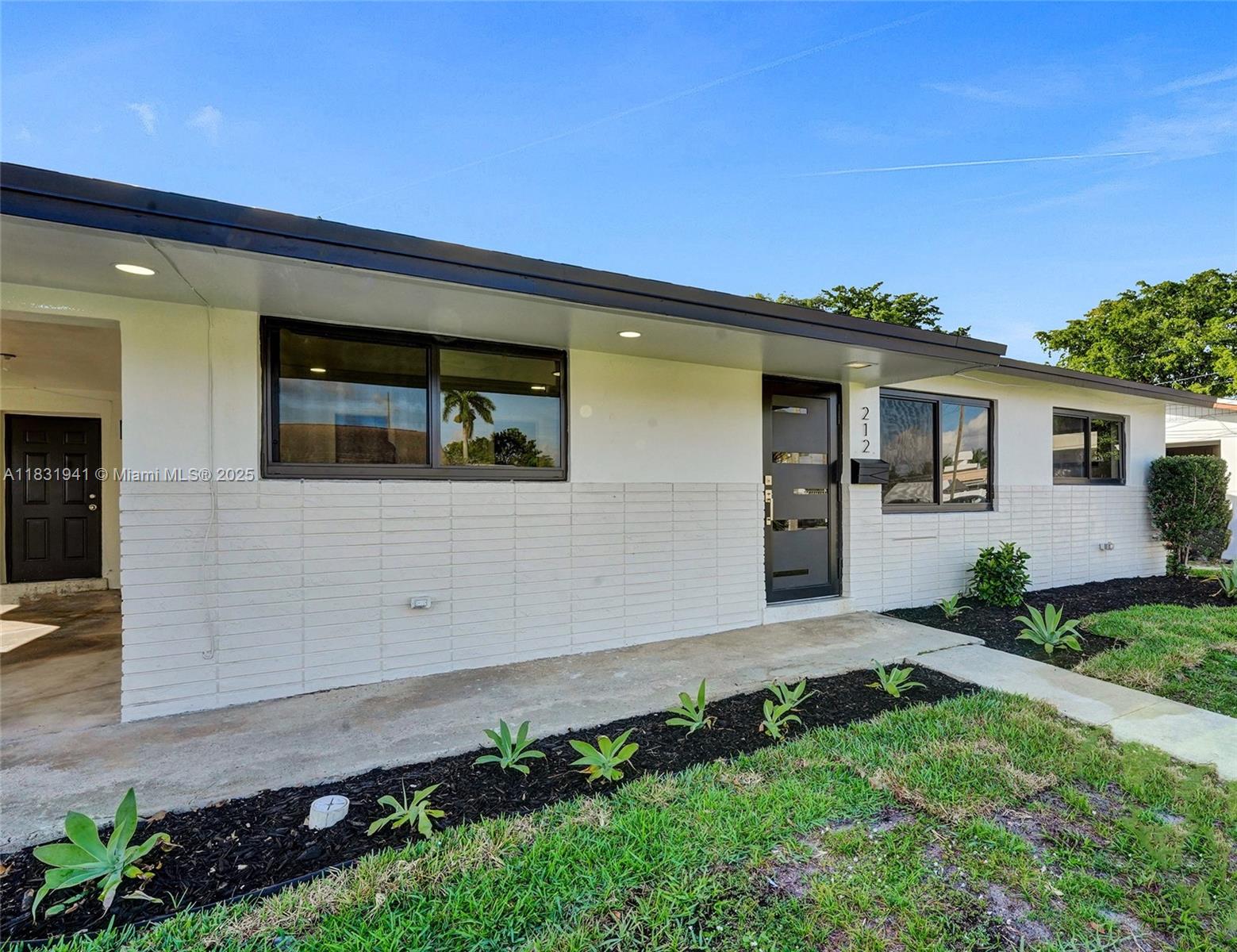 Experience lakefront living in this beautifully upgraded 3BD/2BA home featuring porcelain tile floors throughout. Enjoy a brand-new kitchen with quartz countertops, waterfall edge, and new cabinetry. Both bathrooms have been fully remodeled with quartz finishes. Recent improvements include a new roof, impact windows and doors, new central A/C, tankless water heater, and a modern front entry door. An oversized sunroom offers the perfect space for entertaining with peaceful lake views. Located just minutes from Dania Pointe, Fort Lauderdale Airport, and the beach. Appliance credit included. Supra Lockbox located on carport door
