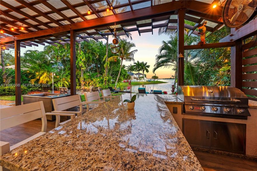 Just imagine if you could have luxury, comfort, & breathtaking views blend seamlessly in your dream Waterfront Villa. Imagine no more! Perfectly situated on an OVERSIZED PREMIUM LOT with pristine designer landscaping, an elegantly tiled terrace along with a dream outdoor kitchen, bar, & grill area that overlook a majestic lake, creating the perfect setting for unforgettable gatherings and peaceful evenings unwinding in the sunset. Inside, the expansive layout flows effortlessly with Soaring Volume Ceilings rare for a single story home and a beautiful array of oversized impact windows & doors throughout the home allowing for tons of natural light & positive energy. The primary suite serves as a private sanctuary with panoramic views of lush tropical landscaping and glimmering water frontage. Its spa inspired bath features a soaking tub & a custom shower with an integrated sauna, offering the full spa experience. The designer kitchen captivates, showcasing rich dark wood cabinetry, rare designer granite countertops & backsplash, an oversized island & views of the water! The entire home is equipped with a Reverse Osmosis Water-Filtration system. Beyond your private oasis,enjoy resort-style amenities including a lakefront pool with a cascading waterfall, basketball, tennis,pickle ball court,a fitness center, & more! Surrounded by A+Schools this dream home is waiting for your family to call it home and won't last! Join us for a special Open House this Sun from 10-12:30pm.