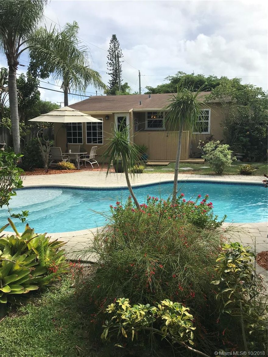 This remodeled and updated home is a blend of the 1950's Florida Home and the California Bungalow styles.  The unenclosed rafters as you walk into the front door, the proximity to the kitchen and other living areas create a cozy atmosphere.  The home features new impact doors and windows, stainless steel appliances and rustic wood floors.
The backyard is a tropical and private oasis with a freeform swimming pool featuring a bubbler fountain surrounded by a paving stone pool deck.  The poolside setting features two separate tented seating areas surrounded by mature lush landscaping; the perfect environment for entertaining. Location is great for a bed and breakfast, Air B&B and only footsteps to Wilton Dr.
