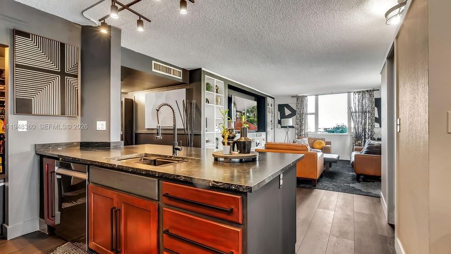 Updated 2-bedroom, 2-bath condo in the heart of Hollywood featuring vinyl flooring, stainless steel finishes, and a modern kitchen with granite countertops and an island. The kitchen is equipped with a Samsung Bespoke smart appliance package, including a slide-in electric range with precision knobs, a 4-door French door refrigerator with Family Hub, and a quiet top-control dishwasher with a third rack. Updated bathrooms and custom-built cabinetry add both style and functionality. Impact windows and sliding doors (2024) provide enhanced security and energy efficiency. Elevator access available in the building. Conveniently located approximately 13 minutes to Hard Rock Stadium, 5–7 minutes to Hollywood Beach and Boardwalk, and a short drive to The Club at Emerald Hills. Close to dining, shopping, beaches, and entertainment, making this an ideal primary residence.