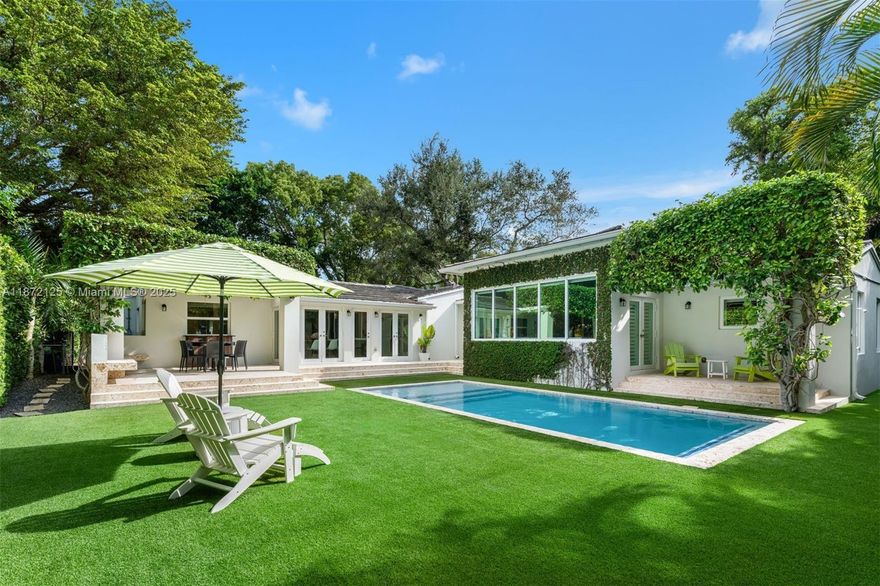Exquisite 3BR/3BA + office one-story residence in Coral Gables with 2,872 total SF on a 9,375 SF lot. Surrounded by lush landscaping, the home offers a heated saltwater pool with lighting, coral stone patio, pergola for alfresco dining, ivy-clad walls, and an outdoor shower. Interiors blend elegance and comfort with all-new floors, impact French doors/windows including smart glass technology, fluted paneling, and custom finishes. The open kitchen features bespoke cabinetry, granite counters, and luxury appliances. The principal suite boasts dual walk-ins and spa-like bath with soaking tub, glass shower, and dual vanities. Additional highlights: all new bathrooms, upgraded climate control systems, refined laundry room, and 1-car garage with storm-grade doors.