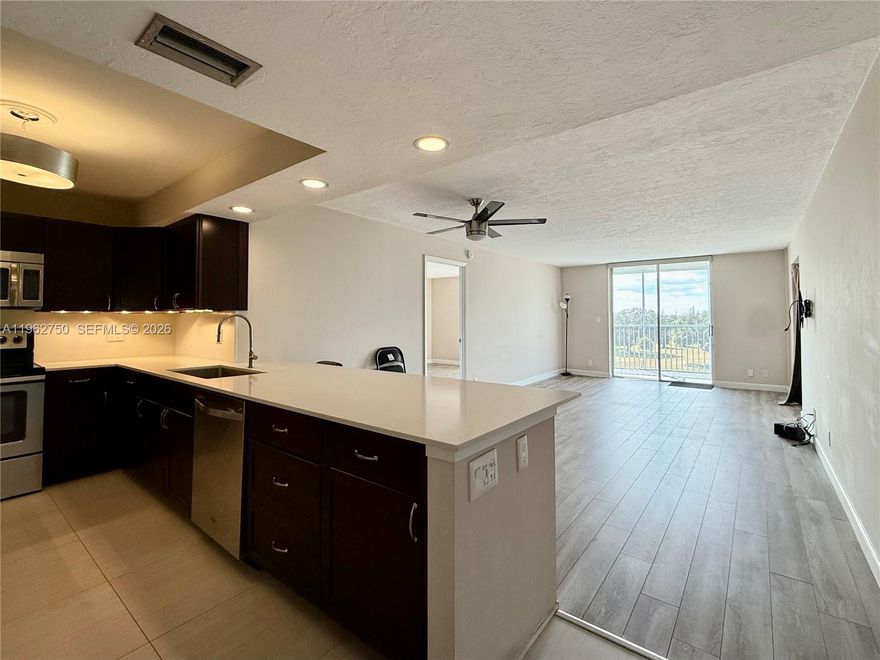 Fully renovated penthouse corner residence offering 2 bedrooms, 2 bathrooms, plus a den that can be easily converted into a third bedroom or office. Completely updated throughout with all-new finishes. The modern kitchen features dark wood cabinetry, stainless steel appliances, quartz countertops, and LED lighting. Tile flooring in the kitchen and baths, complemented by white wood vanities and striking stone countertops. Warm wood-look laminate floors flow through the main living areas.