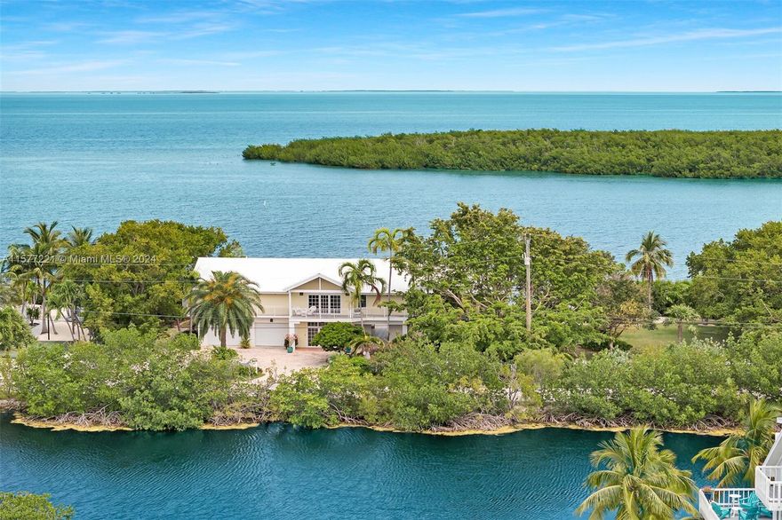 Nestled at the secluded end of a private road in Islamorada's premier boating neighborhood, is a remarkable property with breathtaking bay vistas and unmatched seclusion. Completely rare 200 feet along Florida Bay on 3/4 of a lush green acre! Floating dock for flats boat is right behind the house and two slips in the private marina just 800 feet away, each accommodating boats up to 40’ LOA. The sprawling one-level home features cathedral ceilings, oversized windows framing panoramic bay views. A screened porch offers a serene bay-facing retreat, while the primary suite and a separate wing with office and guest quarters ensure ample space for relaxation and hosting. 3,000SF+/- under AC and abundant outdoor living spaces, PLUS 1500sf garage and 560sf workout room. Metal roof, mostly impact.