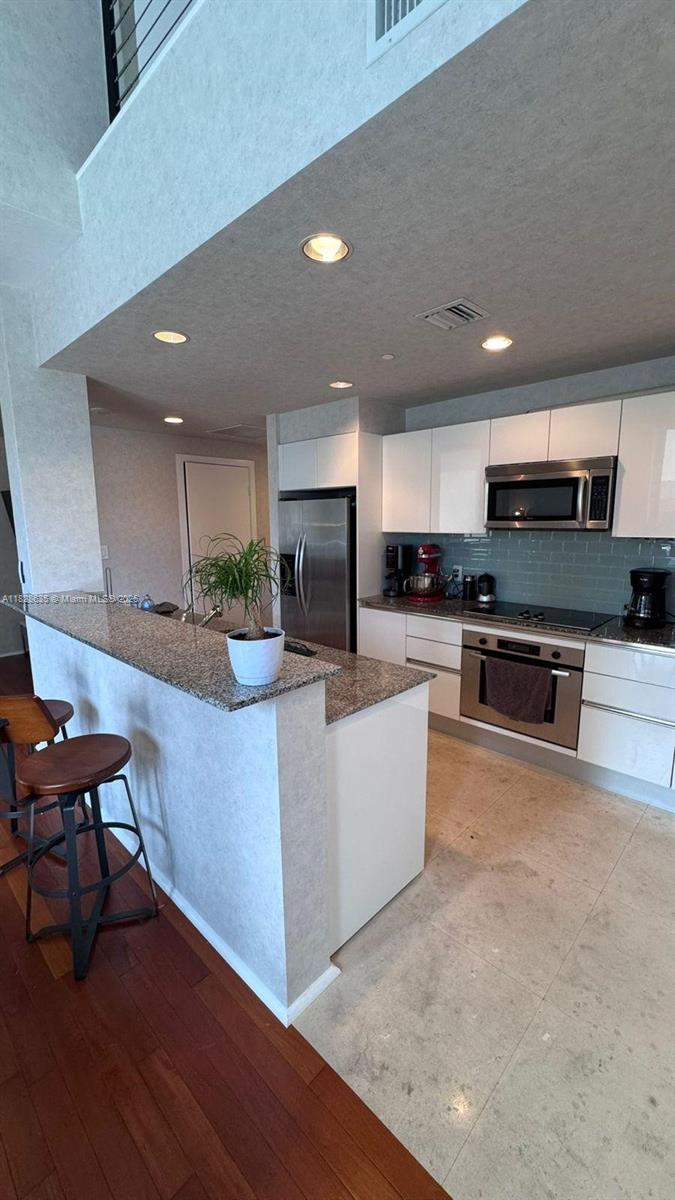 Rare corner duplex loft + den filled with natural light! Features Brazilian cherry wood floors, marble kitchen, and full bathroom upstairs with dual sinks, plus a guest half bath downstairs. Impeccably maintained and move-in ready. Parking on same 4th floor near elevator. Priced competitively per sq. ft. in a building with top amenities. Prime location—walk to shops, restaurants, and entertainment. A must-see!